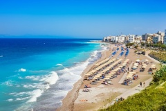 Aegean beach with sunshades in city of Rhodes (Rhodes, Greece)